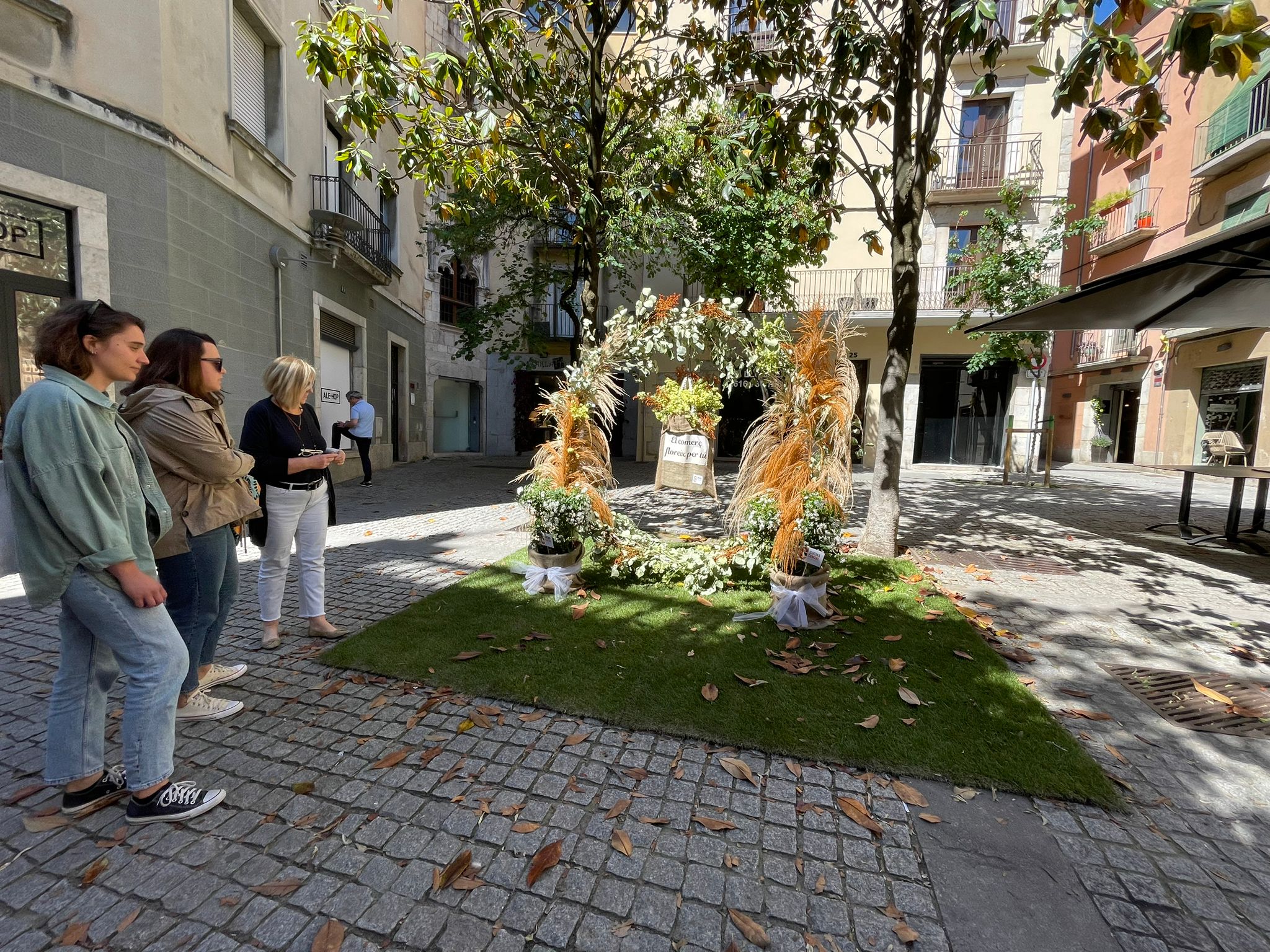 Projecte Temps de Flors al carrer Santa Clara. Visitants miren el muntatge