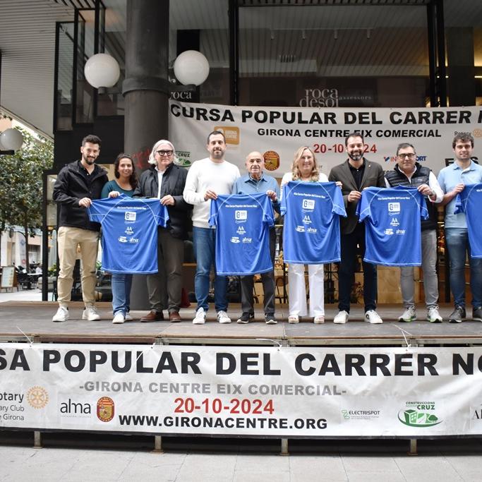 Els representants de Girona Centre Eix Comercial i l’Ajuntament de Girona (al centre) acompanyats dels principals patrocinadors d’aquest any, amb la samarreta de la 45a edició.